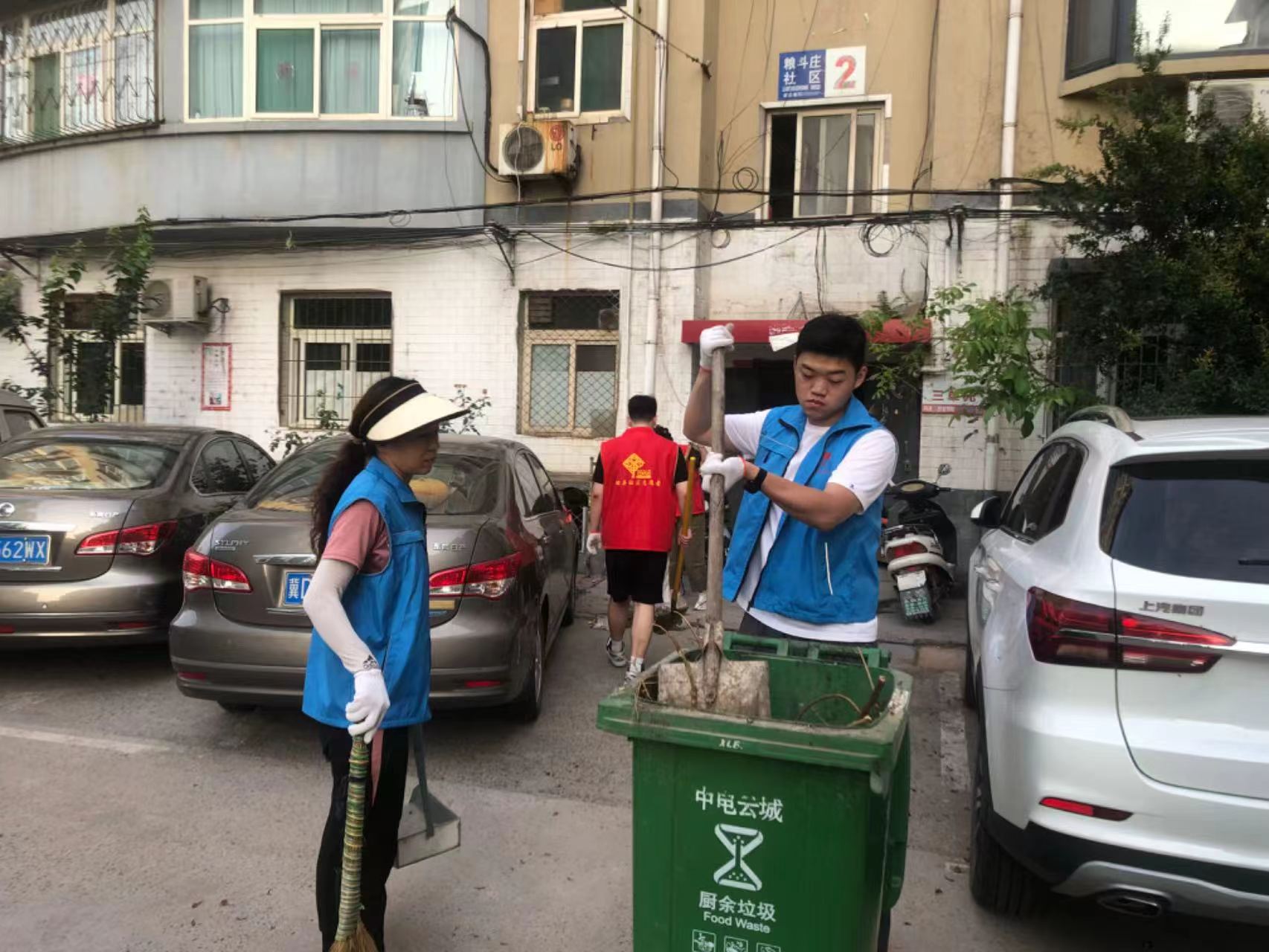 志愿者在居民楼前共同清运杂物